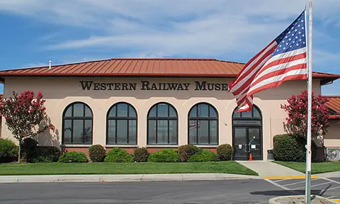An exterior view of a building with an American flag flying in the foreground.