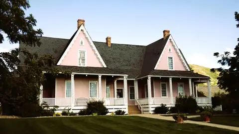A pink historic house with multiple gables and porches.