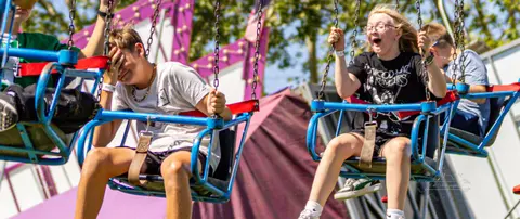 People ride a swing ride at a carnival.