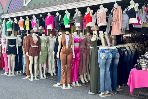 A large outdoor display of mannequins showcasing various women's clothing outfits.